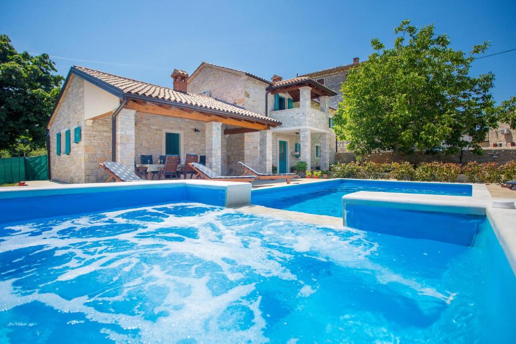 a large swimming pool in front of a house at Villa Medvidići in Rajki