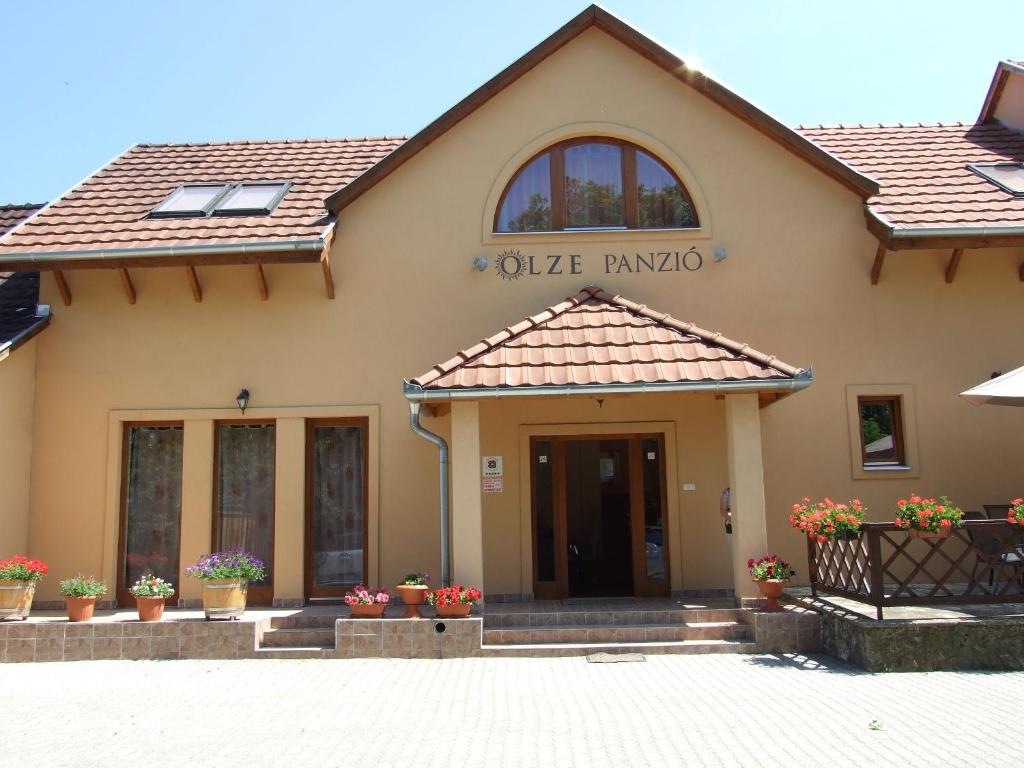 a building with the entrance to an olive pharmacy at Olze Panzió in Erdőbénye