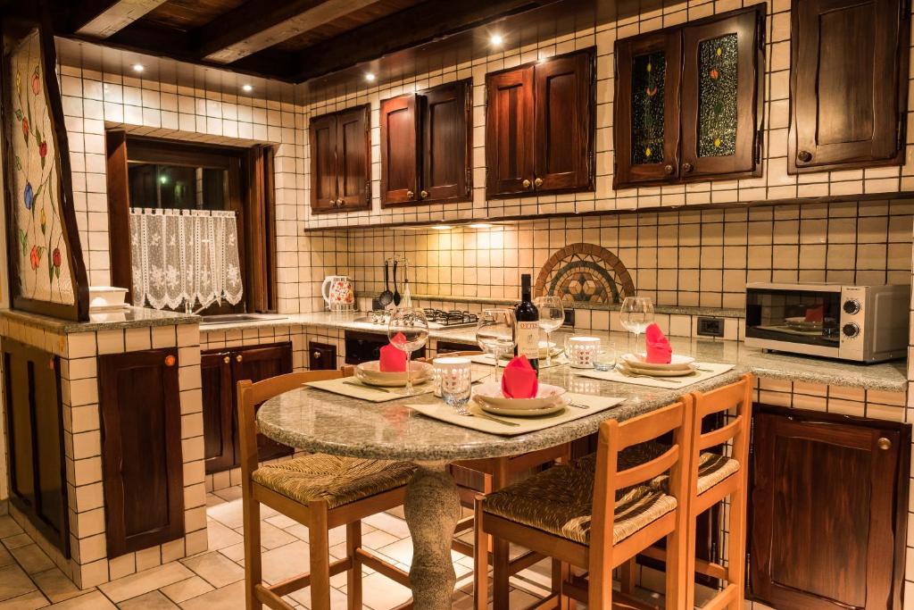 - une cuisine avec une table avec des chapeaux rouges dans l'établissement La Casetta di Francio & Marta, à Aoste