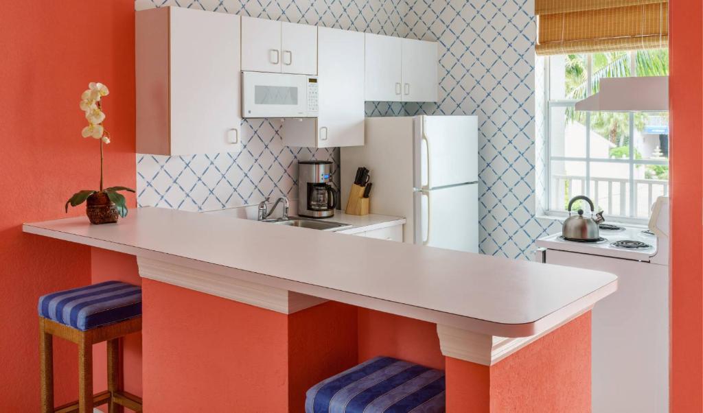 a kitchen with a counter and a white refrigerator at Olde Marco Island Inn and Suites in Marco Island