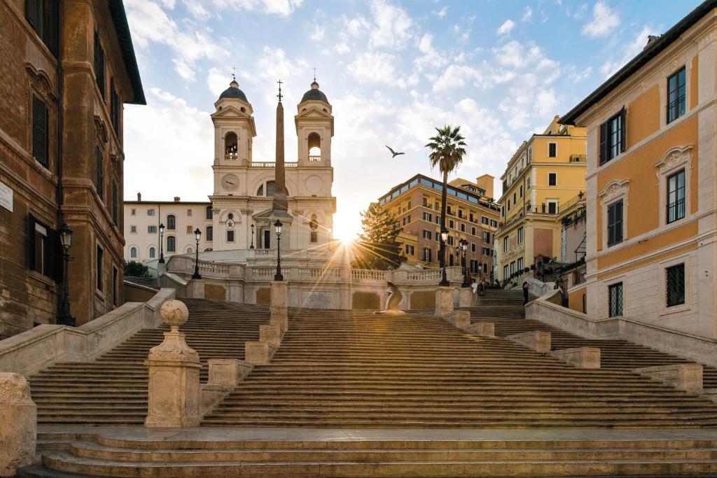 un escalier en face d'un bâtiment avec une tour dans l'établissement Hassler Roma, à Rome