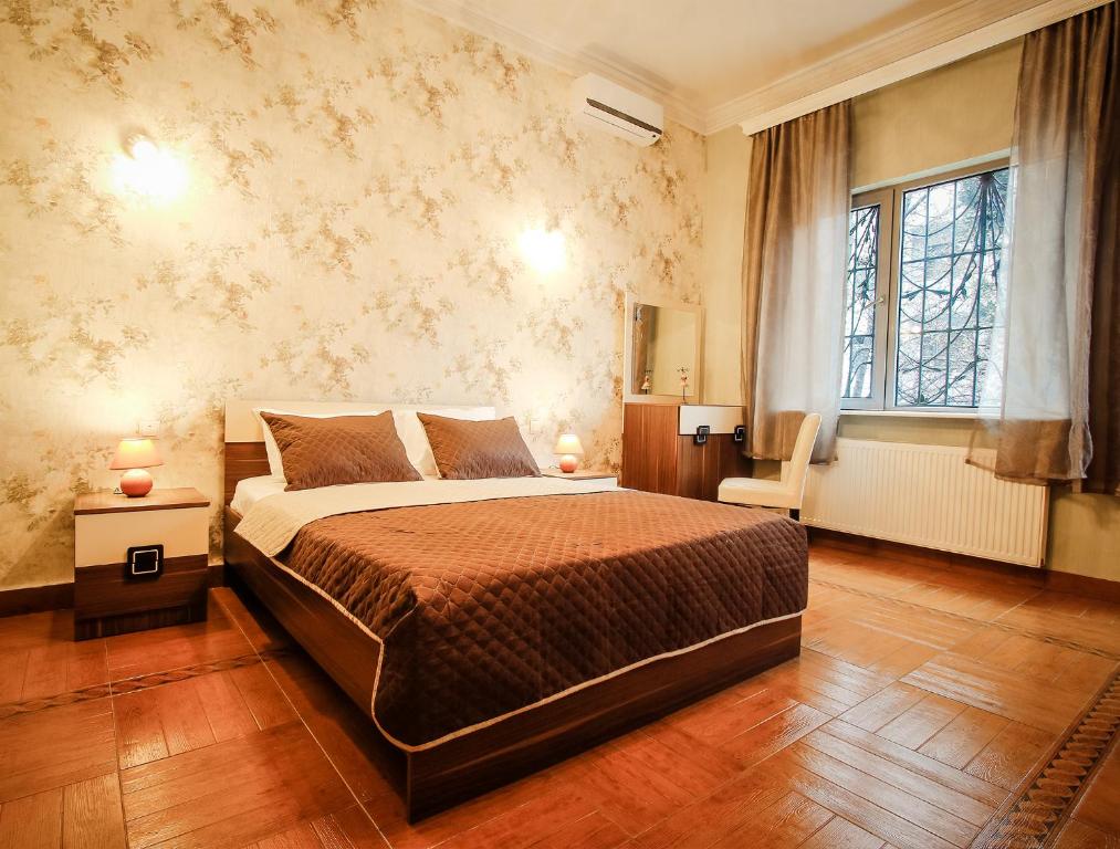 a bedroom with a large bed and a window at Hotel Toma's House in Tbilisi City
