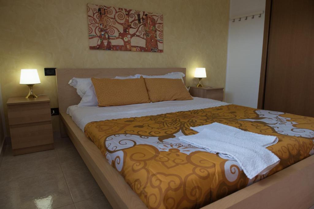 un grande letto in una camera da letto con due lampade di Via del Mare a Lanciano