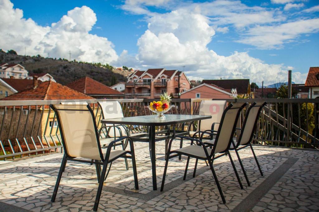 a patio table and chairs on a balcony at Castelomi in Podgorica