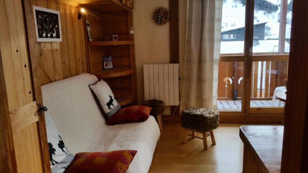 a living room with a white couch and a large window at Joli petit appartement cosi 5 personnes maxi plein centre station les deux alpes in Les Deux Alpes