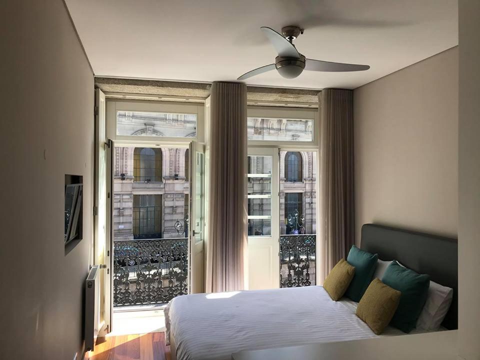 Schlafzimmer mit einem Bett vor einem Fenster in der Unterkunft Apartamento Cardosas, São Bento in Porto