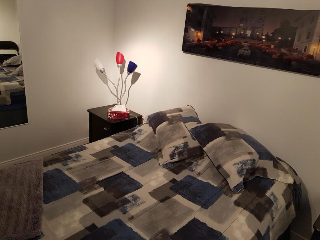 a bed with a comforter and pillows in a bedroom at Gite La Ptite Falaise hébergement touristique in Sainte-Anne-des-Monts