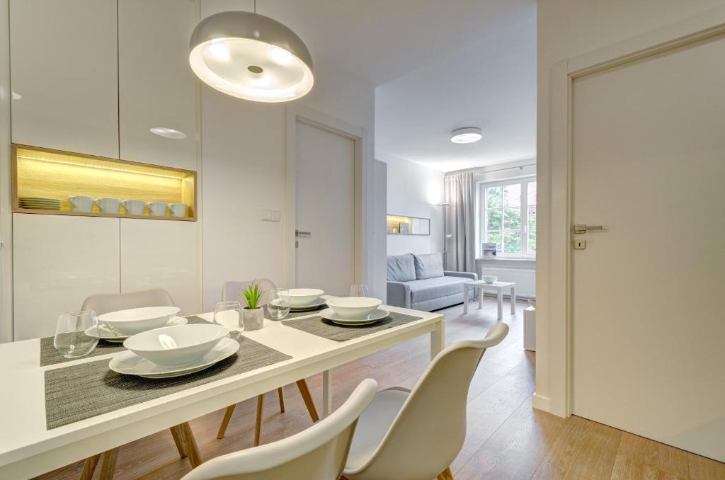 un comedor blanco con mesa y sillas en Apartament 6 Old Town, en Gdansk