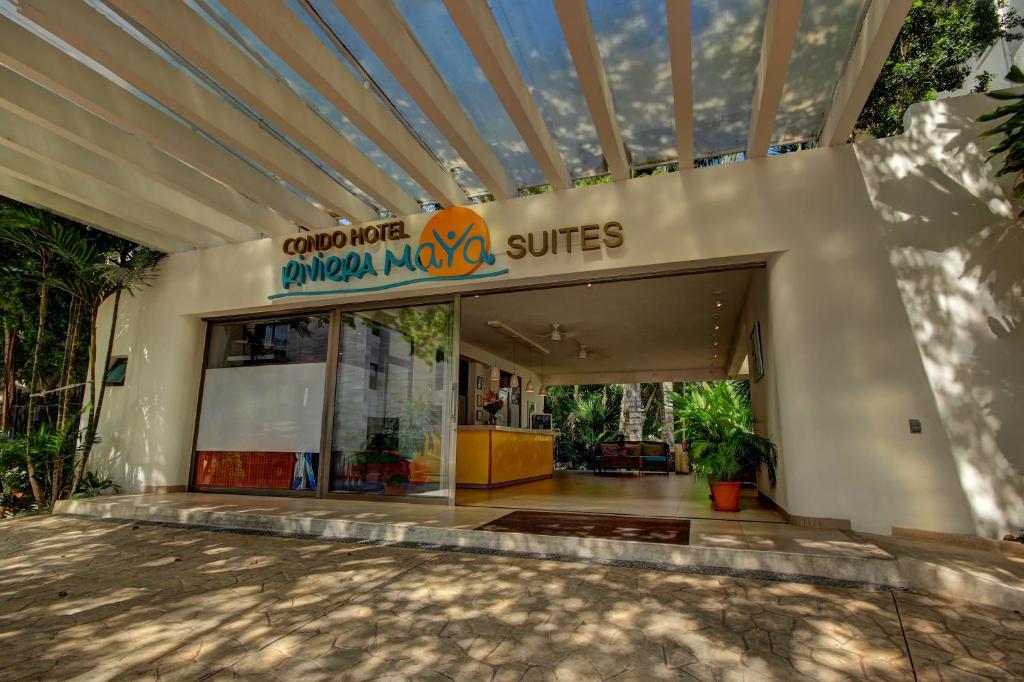 un edificio con un cartel que lee comparar las suites de roca tropical en Riviera Maya Suites, en Playa del Carmen