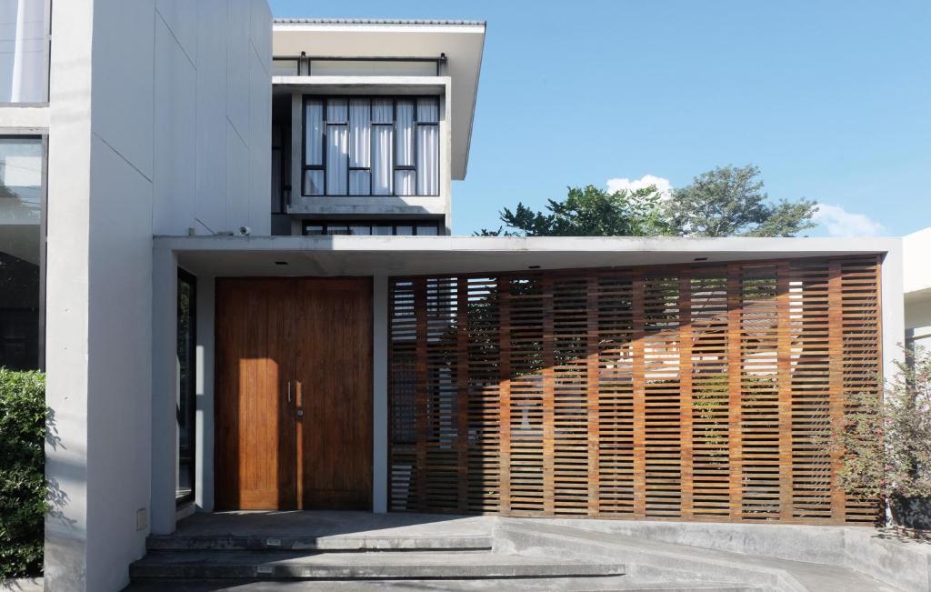 a house with a wooden door and a building at Antique Chiangmai in Chiang Mai