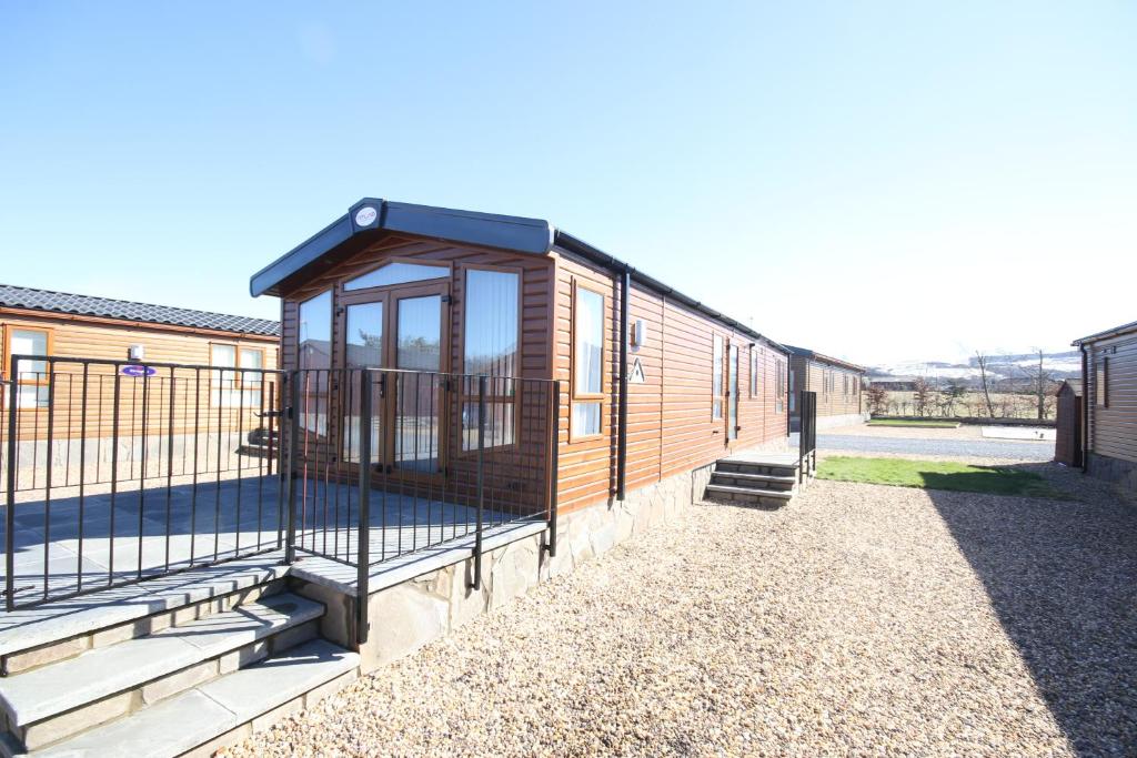 a tiny house with a porch and a fence at Jackson Lodge in Perth