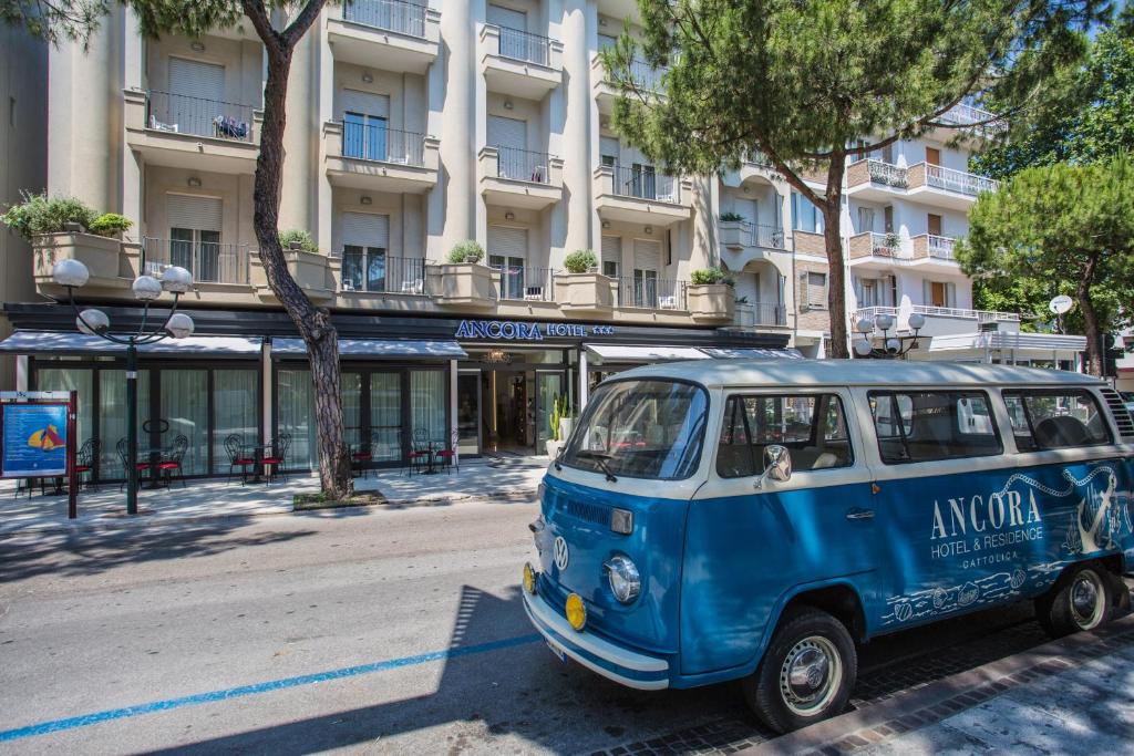uma carrinha azul e branca estacionada em frente a um edifício em Ancora Hotel & Residence em Cattolica