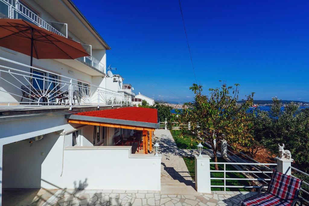 - un balcon avec 2 chaises et un parasol dans l'établissement Apartmani Simundic, à Trogir