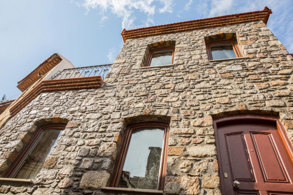 um edifício de pedra alto com janelas e uma porta em Two Stone Homes Metis em Marmaris