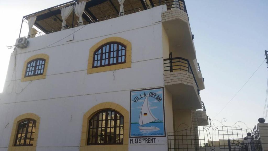 un edificio blanco con un cartel de un velero en él en Villa Dream en Luxor