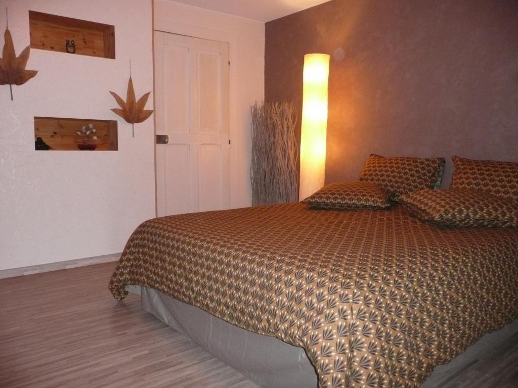 - une chambre avec un lit et une lumière sur le mur dans l'établissement Au Palton, à Raon-aux-Bois