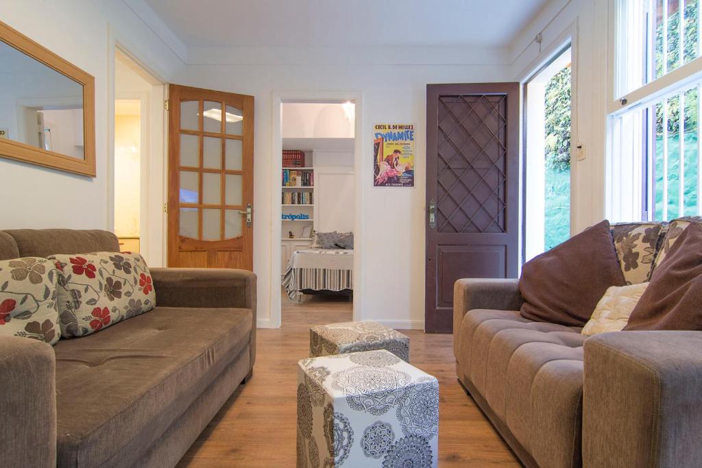 a living room with two couches and a door at Suite Catedral in Petrópolis