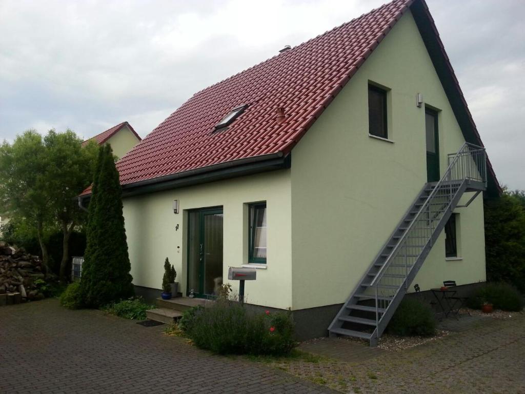 uma grande casa branca com um telhado vermelho em Nahe bei Störti em Ralswiek