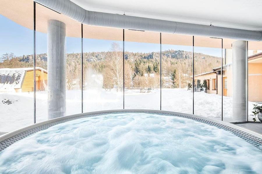 a hot tub in a room with a large window at Hotel Ostrov in Tisá