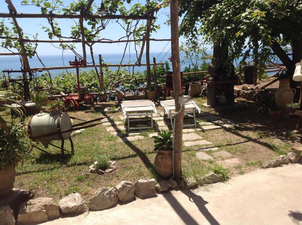 a garden with a table and chairs in the shade at Bella Baia Relais in Maiori