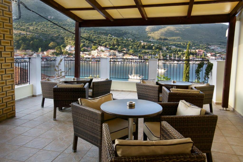 un restaurante con mesas y sillas en un balcón con vistas en Katerina Studios en Agia Efimia