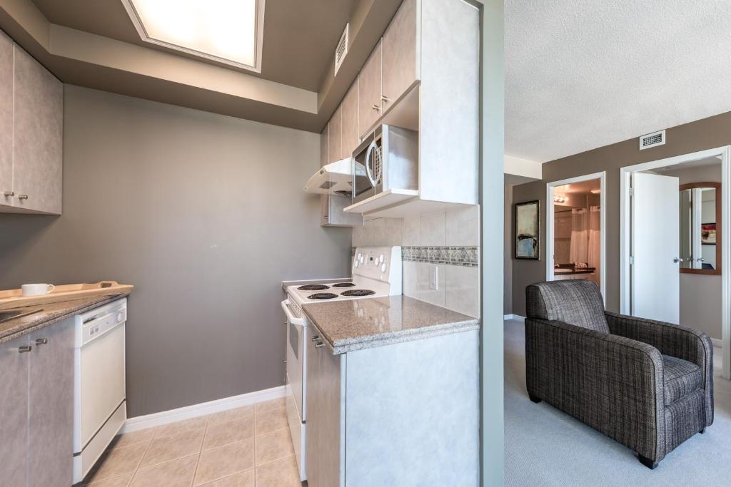 a kitchen with a counter and a chair in a room at Carmana Hotel & Suites in Vancouver