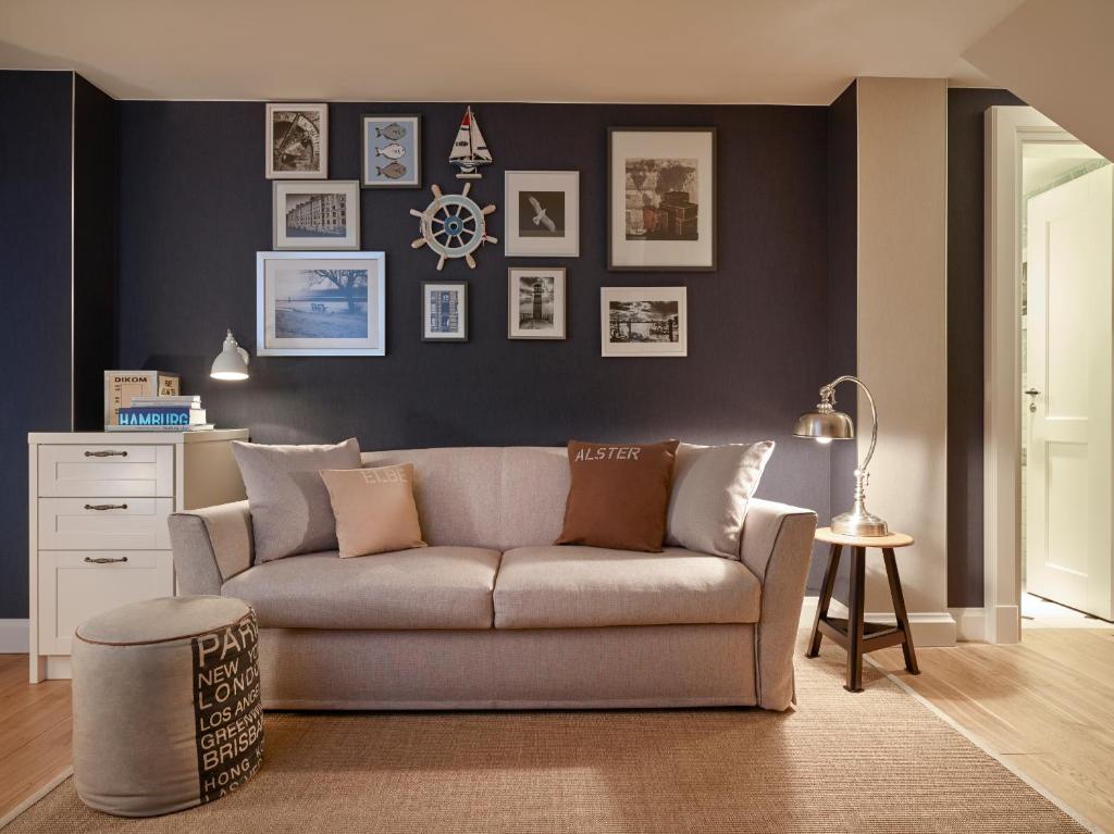 ein Wohnzimmer mit Sofa und eine Wand mit Bildern in der Unterkunft Hapimag Ferienwohnungen Hamburg in Hamburg