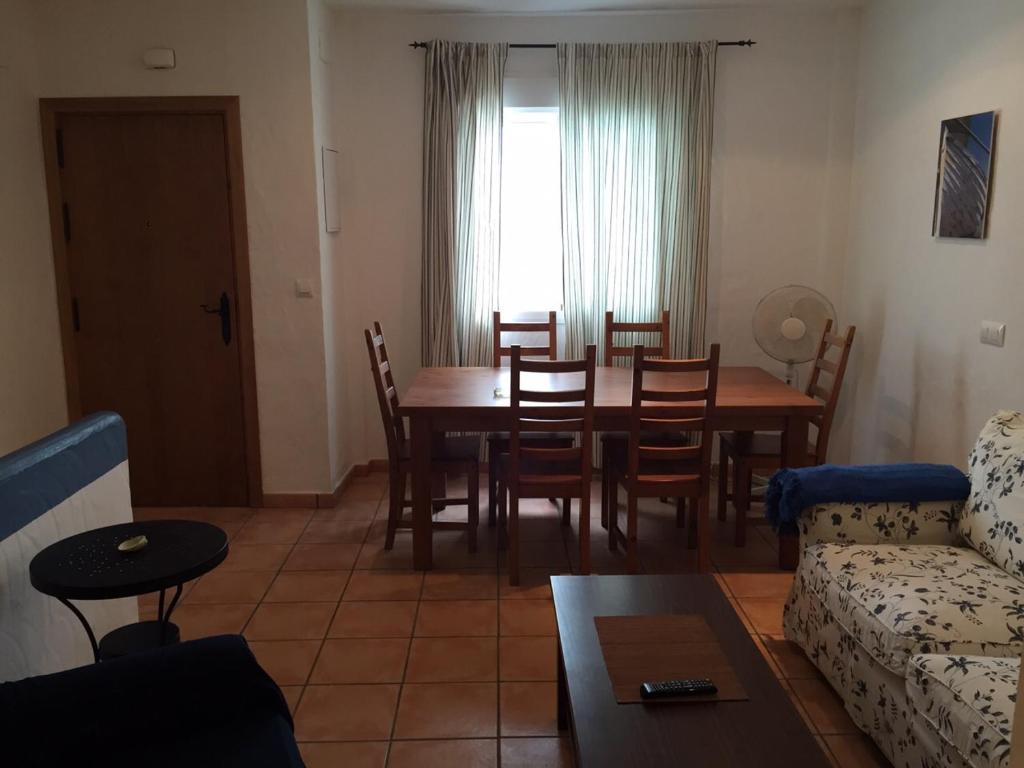 コニル・デ・ラ・フロンテーラにあるApartamento en Conilのリビングルーム(テーブル、椅子、ソファ付)