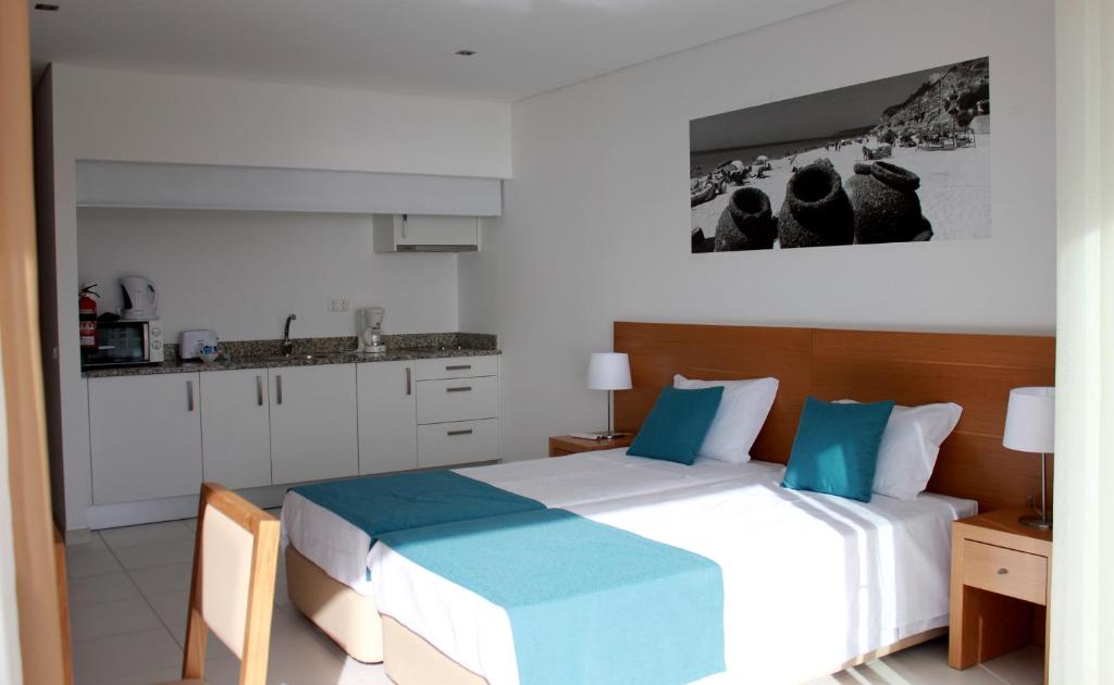a bedroom with two beds and a kitchen at Casa Praia Mar in Salema