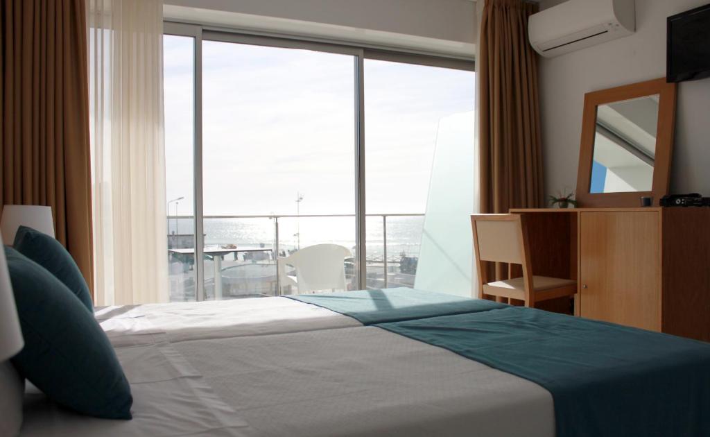 a bedroom with a bed and a large window at Casa Praia Mar in Salema