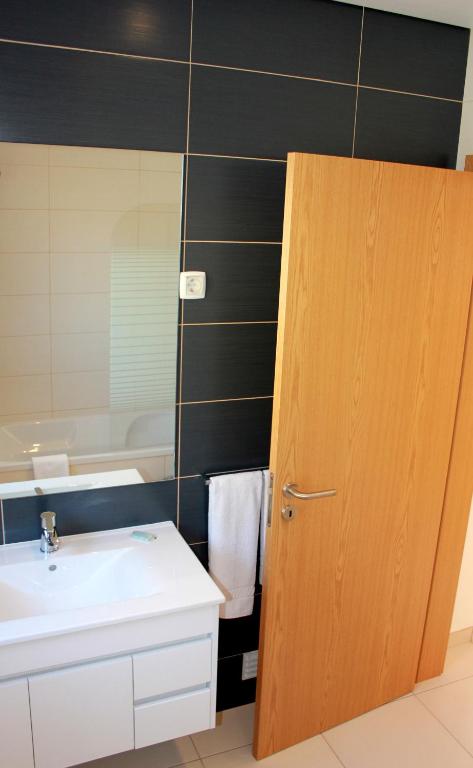 a bathroom with a sink and a toilet and a mirror at Casa Praia Mar in Salema