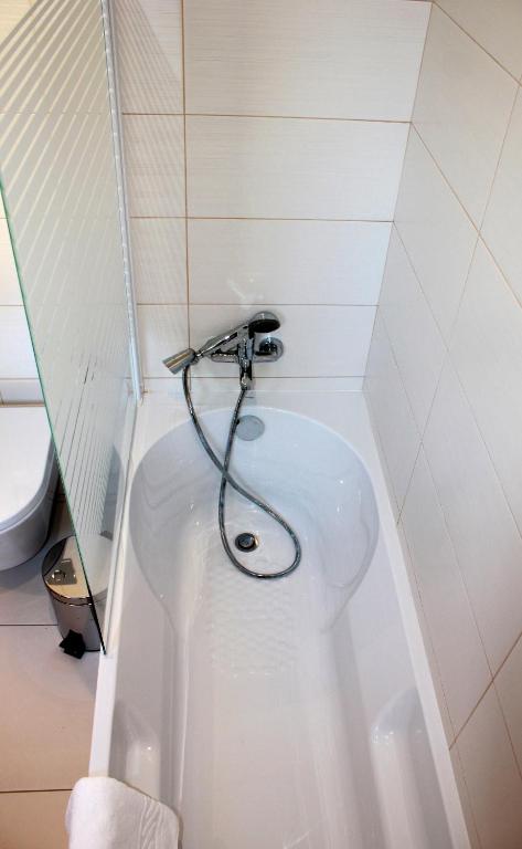 a bath tub with a hose in a bathroom at Casa Praia Mar in Salema