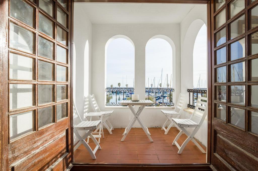 シッチェスにあるHHBCN Port de Sitgesのテーブルと椅子、窓が備わる客室です。