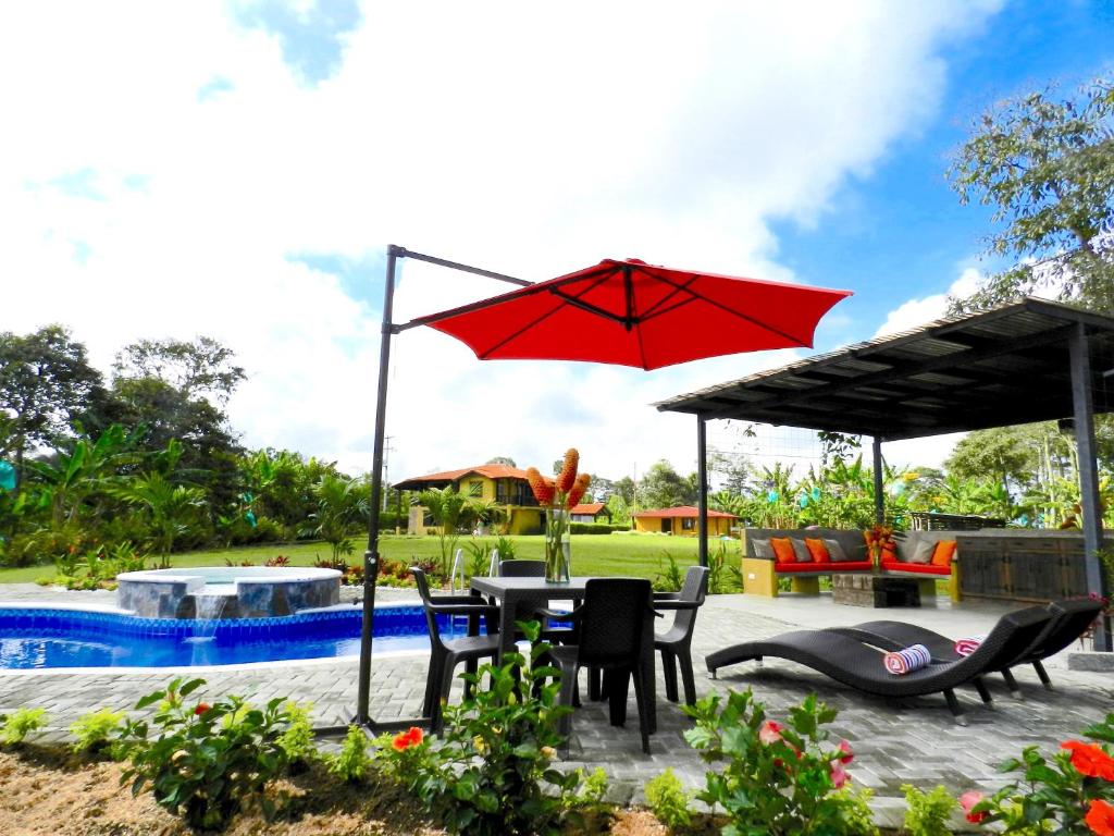 a patio with a table and chairs and an umbrella at Finca La Bambusa in Montenegro