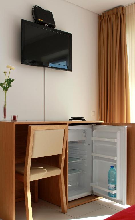 a room with a desk with a tv on the wall at Casa Praia Mar in Salema