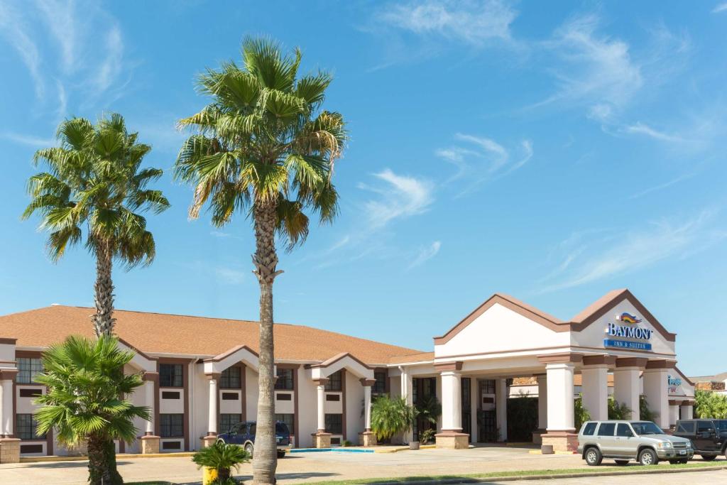 un hotel con palmeras delante en Baymont by Wyndham Port Arthur - Groves Area en Port Arthur