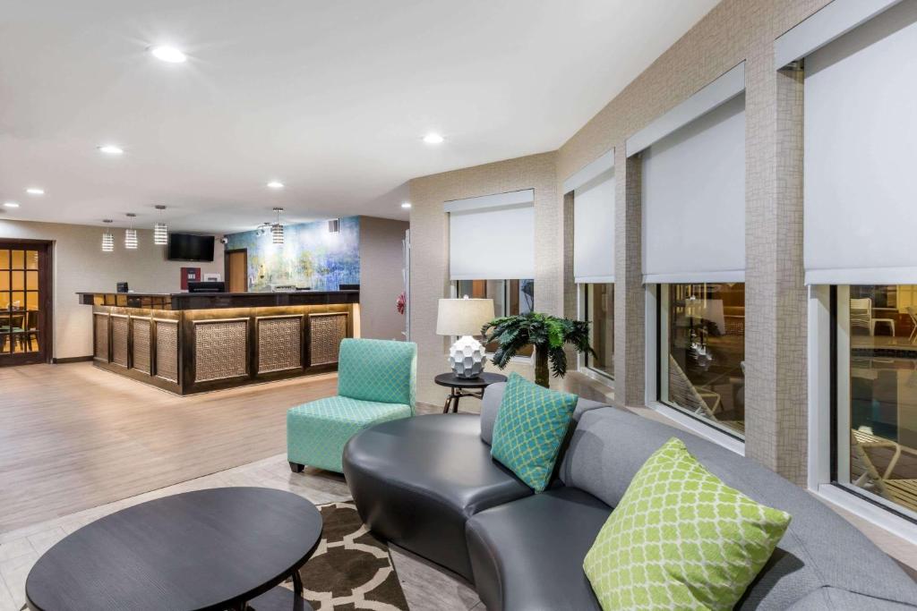 a living room with a couch and chairs and a bar at Baymont by Wyndham Pella in Pella