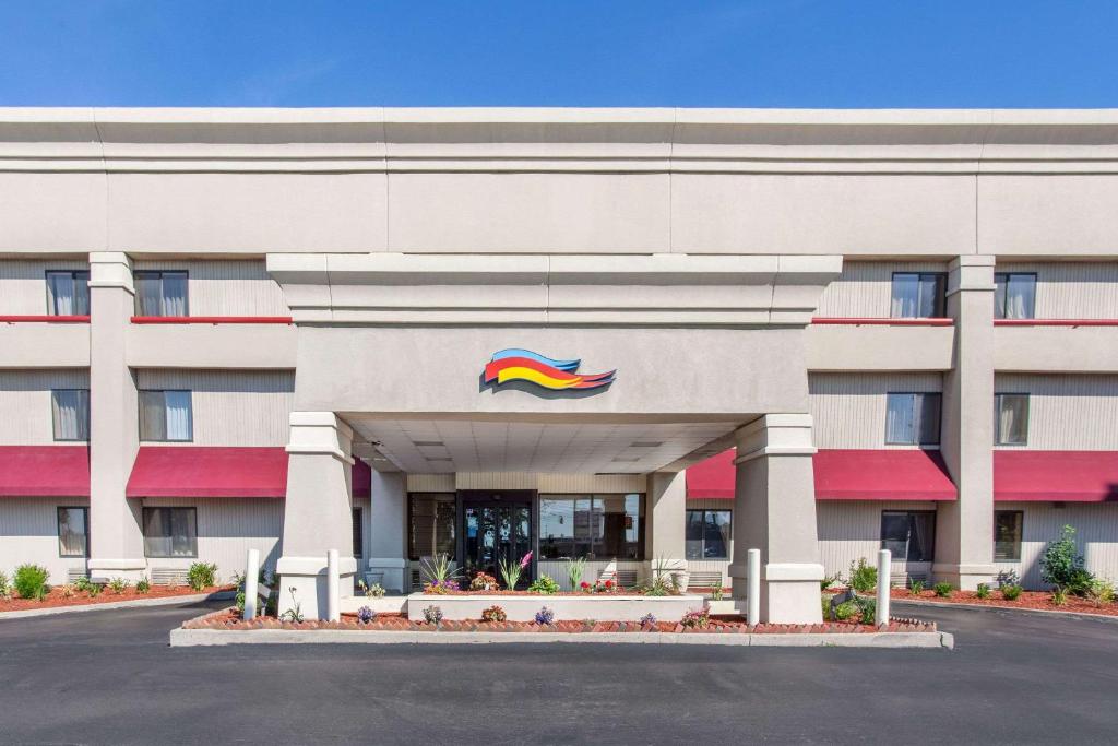 a hotel with a rainbow sign on the front of it at Baymont by Wyndham Detroit/Roseville in Roseville
