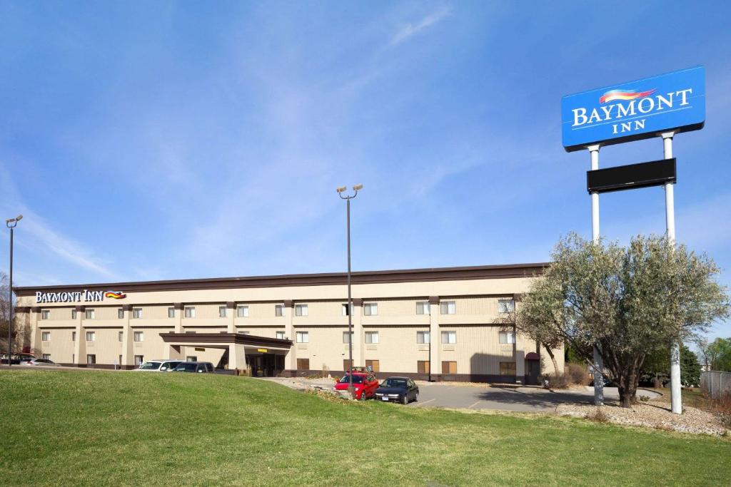 un gran edificio con una señal azul delante de él en Baymont by Wyndham Sioux Falls en Sioux Falls