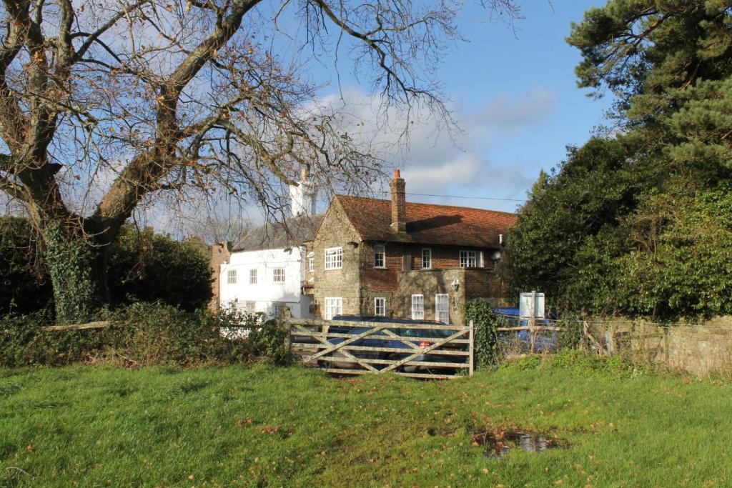 uma casa velha no meio de um campo em Chequers Hotel em Pulborough