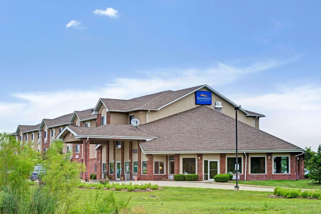 un grand bâtiment en briques avec un panneau bleu dans l'établissement Baymont by Wyndham Indianapolis, à Indianapolis