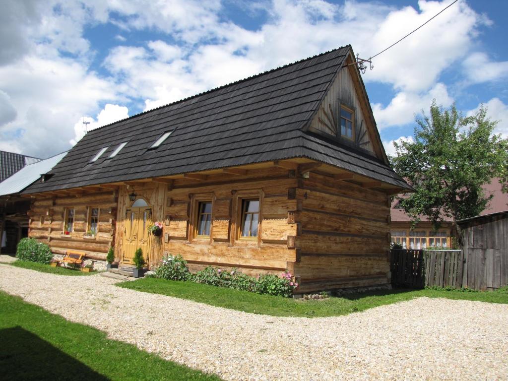 Cabaña de madera con techo negro en BoBak noclegi, en Chochołów