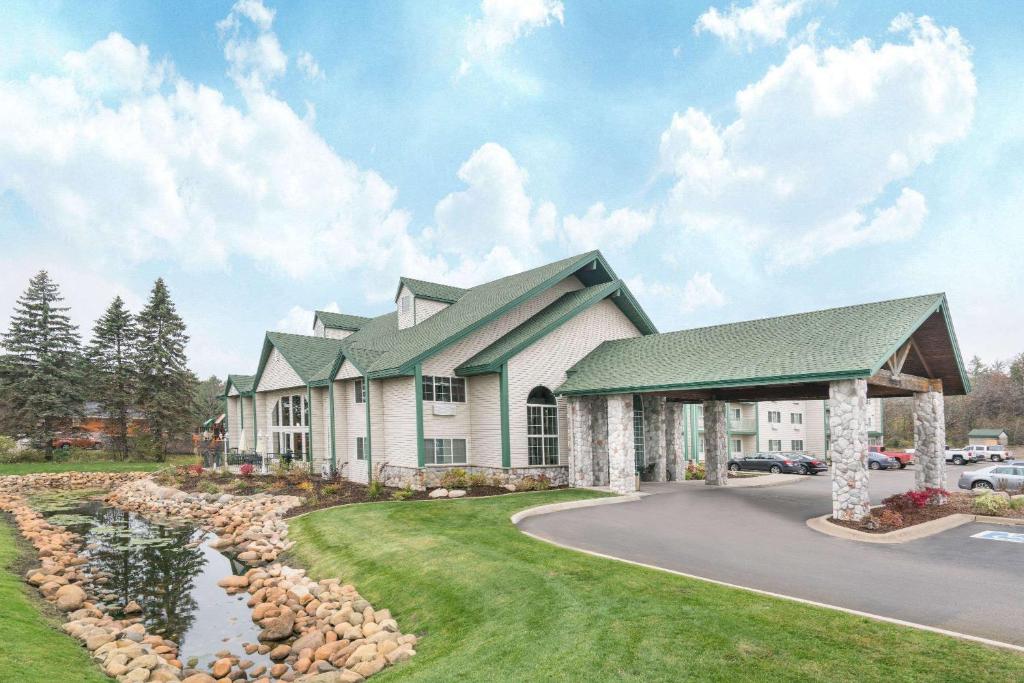 a rendering of the front of a house with a pond at Baymont by Wyndham Baxter/Brainerd Area in Baxter