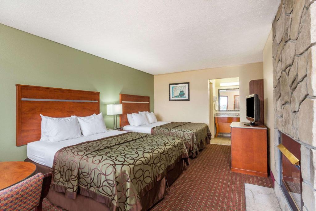 a hotel room with two beds and a flat screen tv at Baymont by Wyndham Pigeon Forge near Island Drive in Pigeon Forge