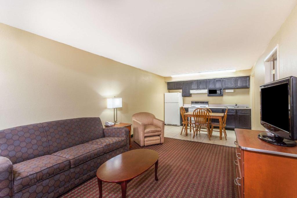 a living room with a couch and a kitchen at Baymont by Wyndham Pigeon Forge near Island Drive in Pigeon Forge