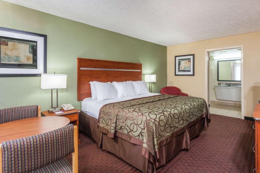 a hotel room with a large bed and a table at Baymont by Wyndham Pigeon Forge near Island Drive in Pigeon Forge
