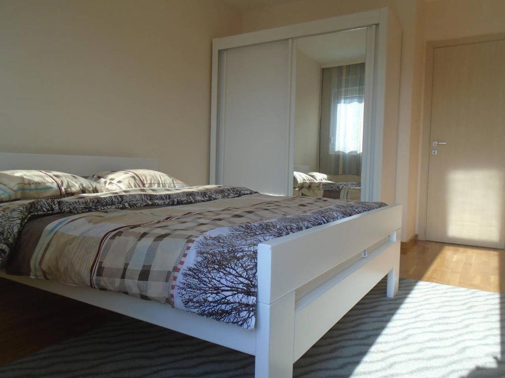 a bedroom with a bed with a large mirror at Fantastic brand new apartment in Podgorica