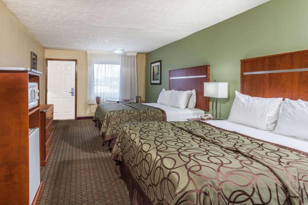two beds in a hotel room with green walls at Baymont by Wyndham Pigeon Forge near Island Drive in Pigeon Forge