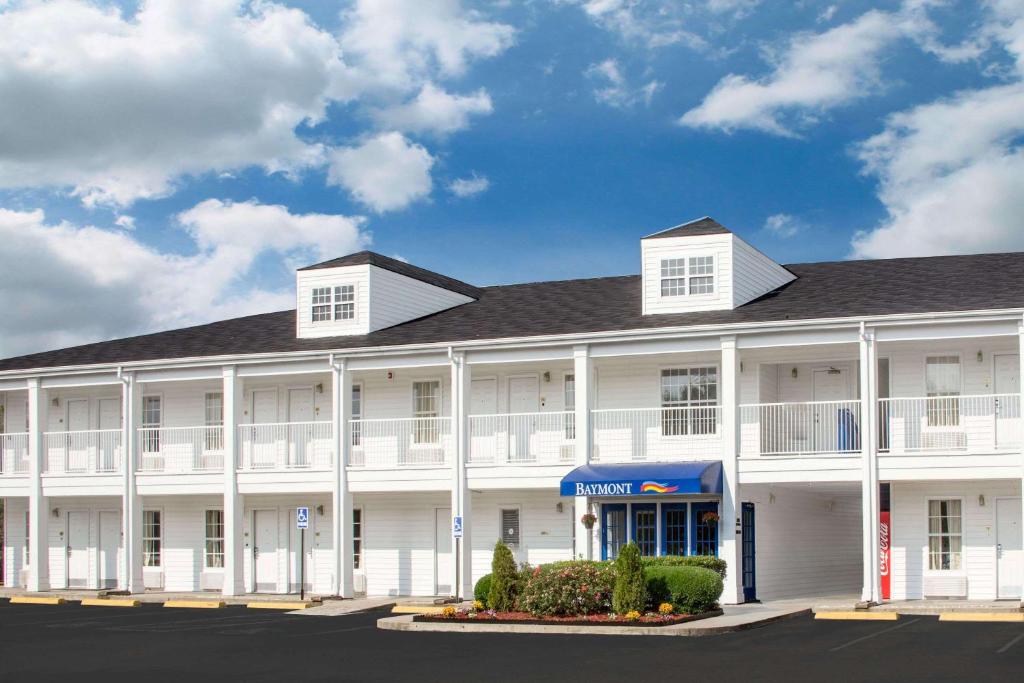 a large white building with a blue awning at Baymont by Wyndham Brunswick GA in Brunswick
