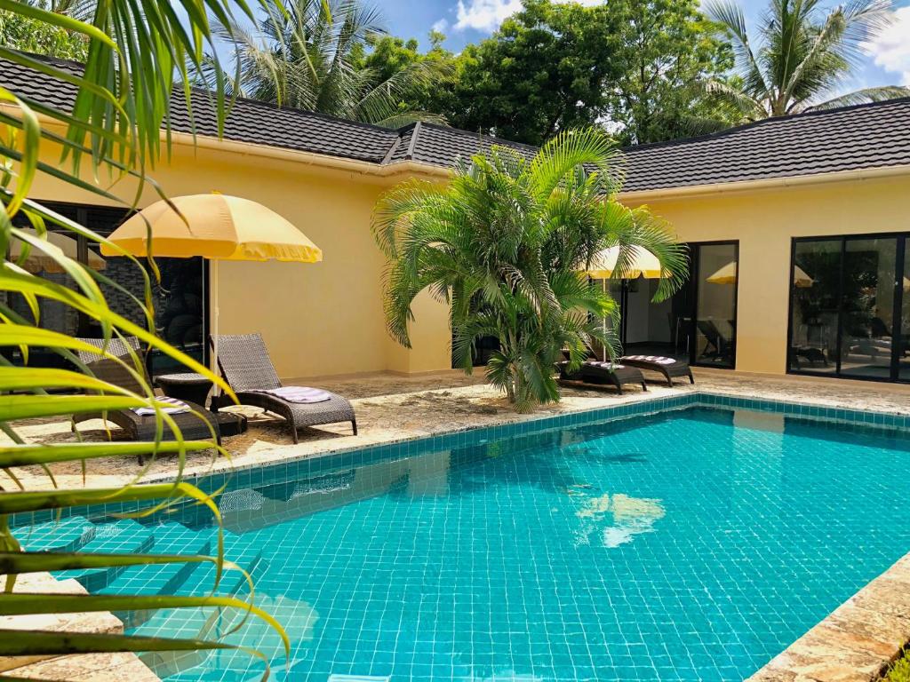 a swimming pool in front of a house at Amber Villas Diani in Diani Beach